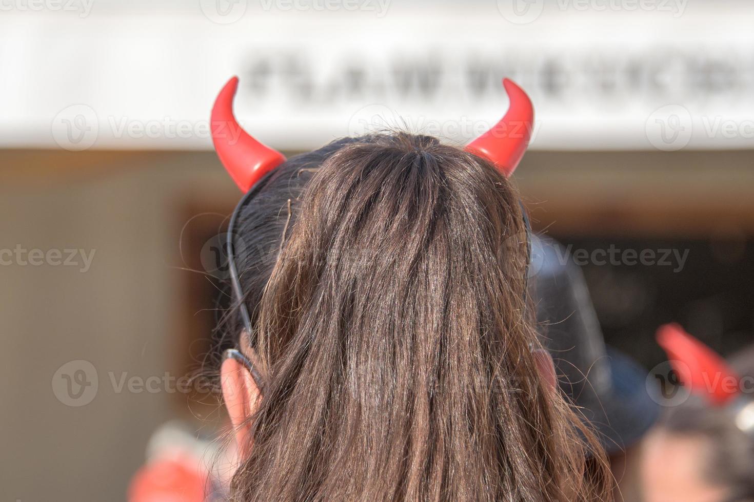 Red devil horns girl from the back photo