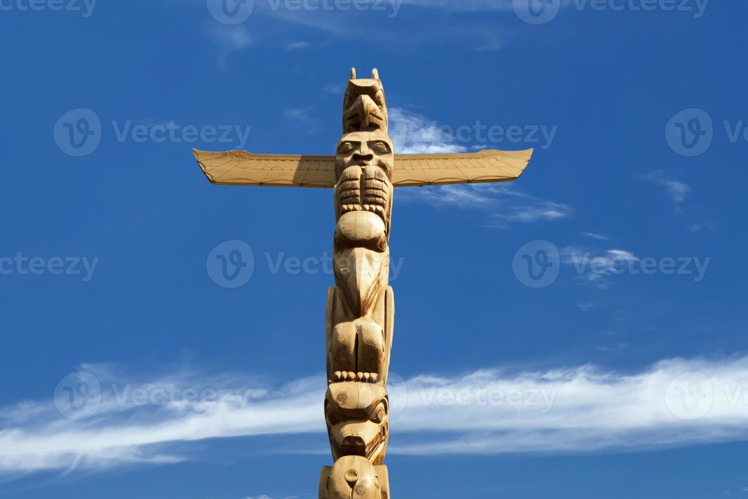 A totem wood pole in the blue cloudy background photo