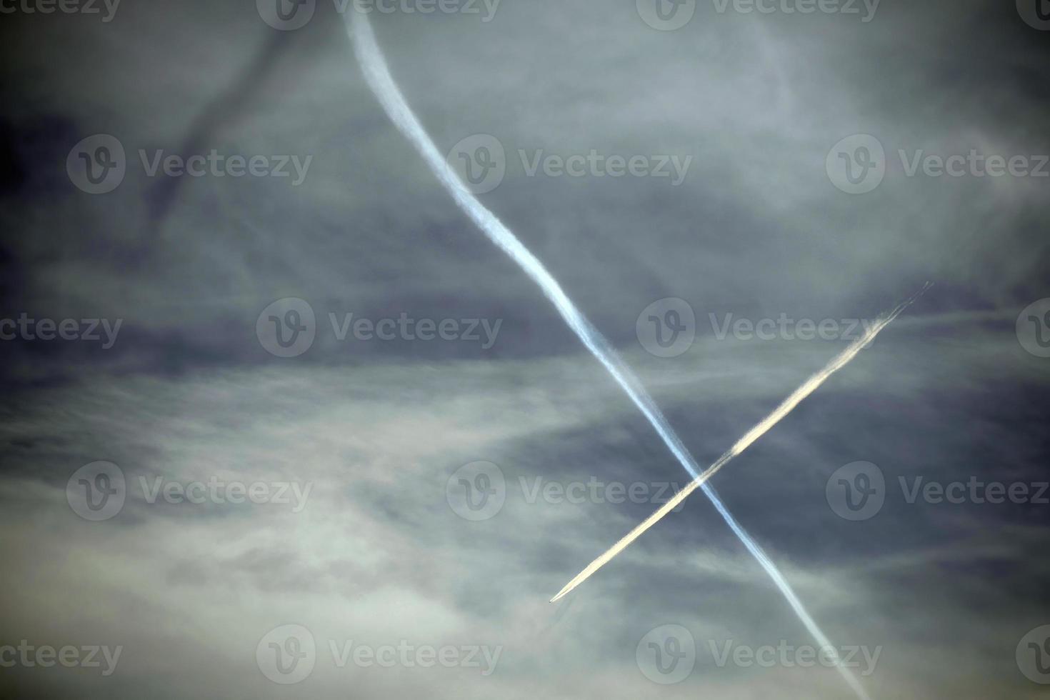 Airplane flying in the blue sky among clouds and sunlight photo