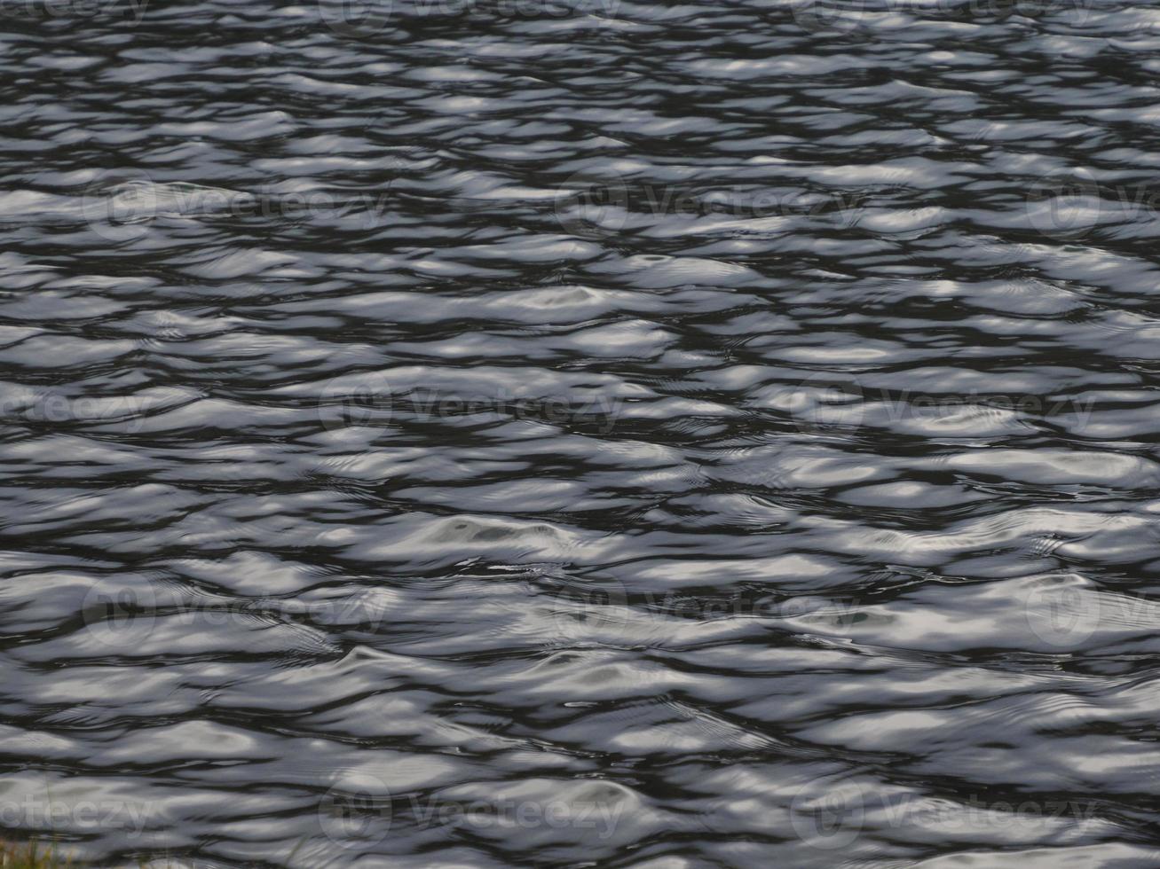 Water texture with reflecting sunlight looking like liquid metal photo