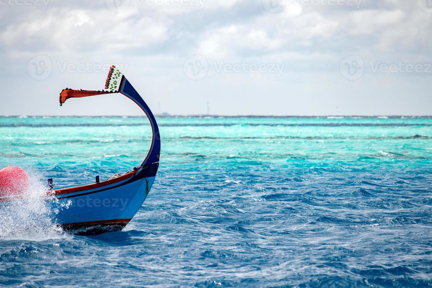 maldivian dhoni boat in blue ocean photo