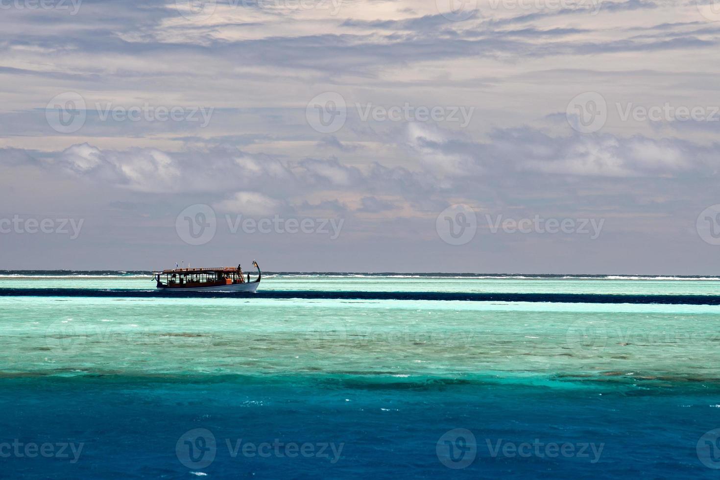 barco dhoni maldivo en el océano azul foto