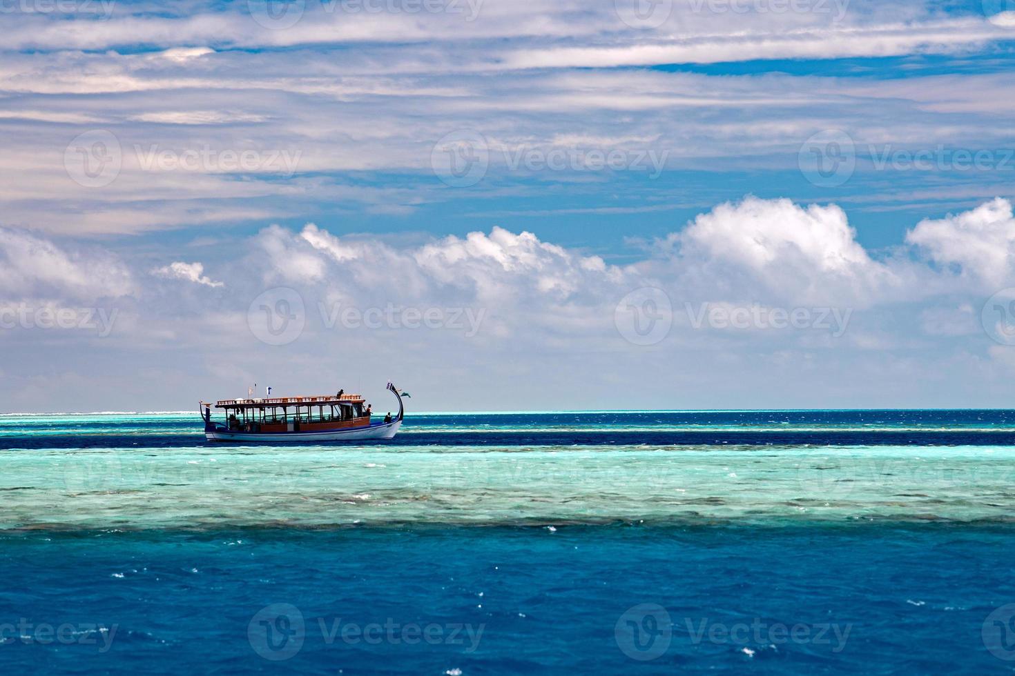 barco dhoni maldivo en el océano azul foto