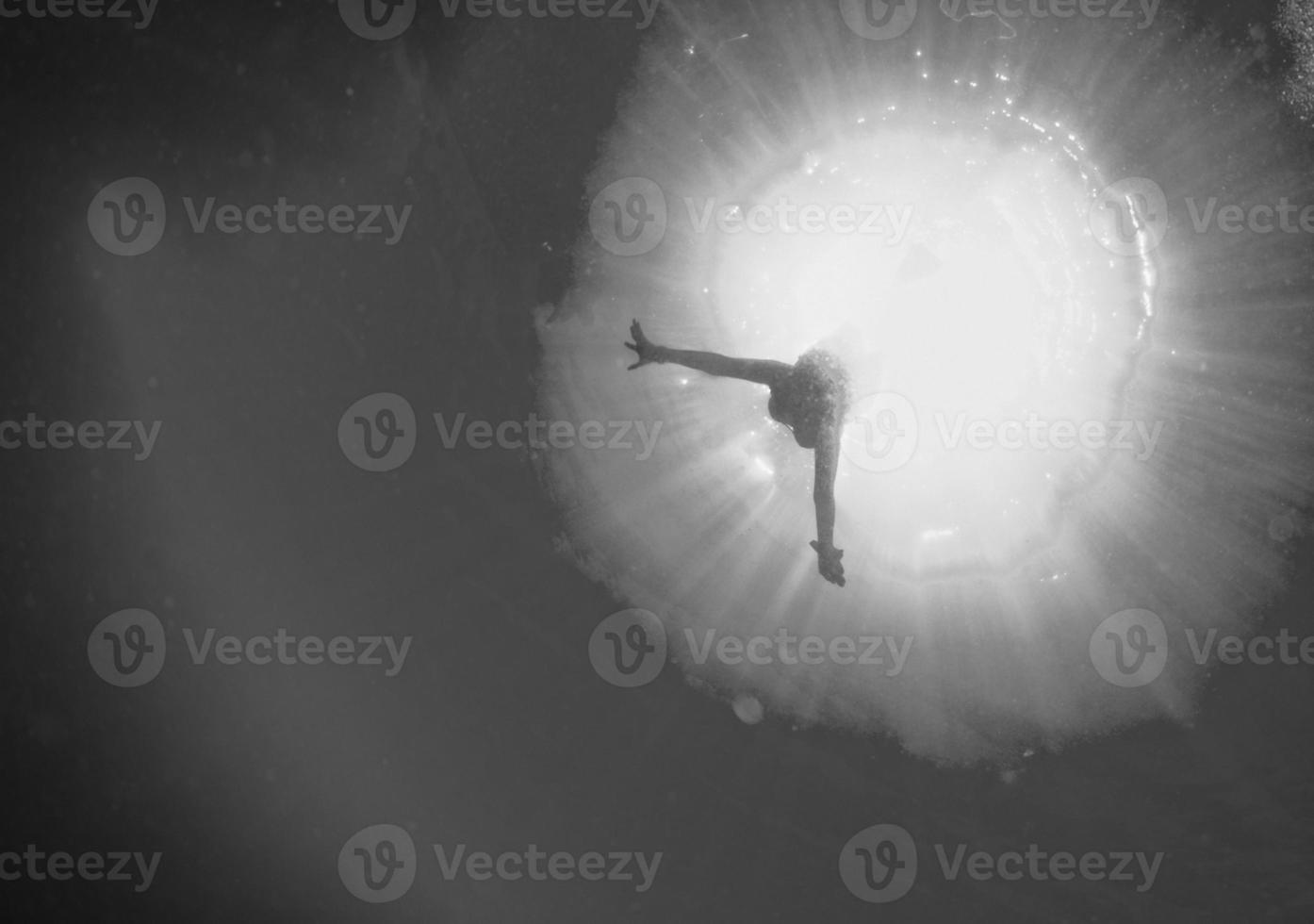 backlight diver underwater coming to the deep ocean photo
