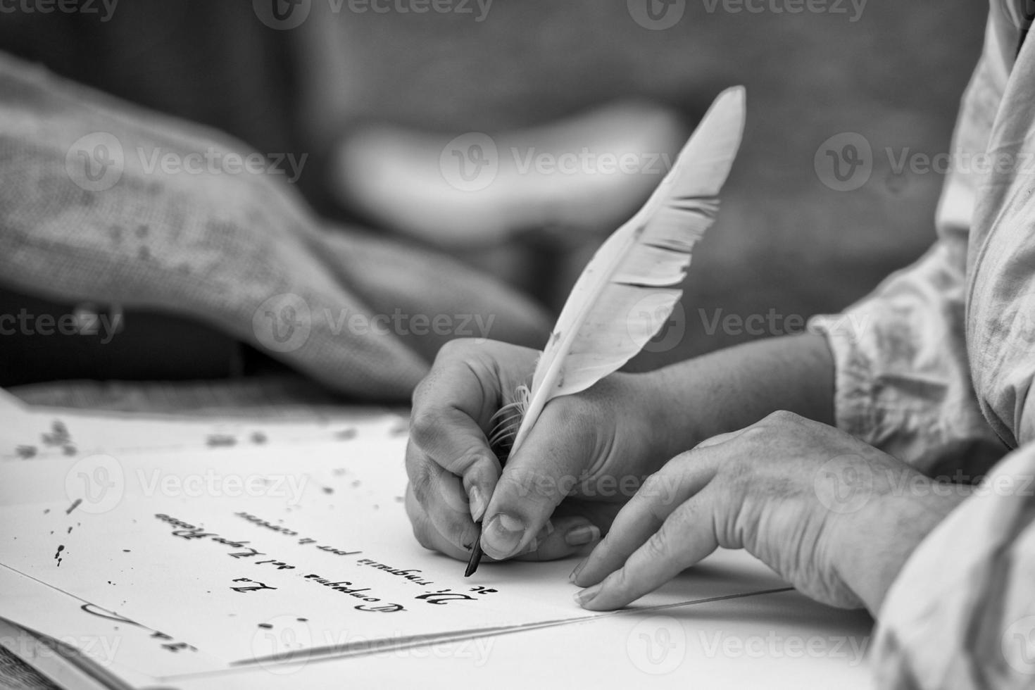 manos escribiendo una carta con un penacho foto