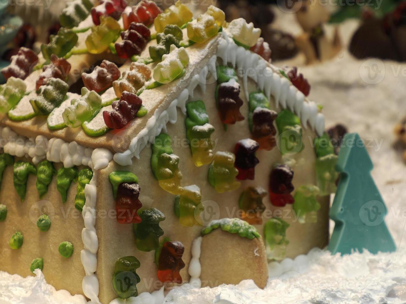 Christmas Gingerbread and chocolate House decorated with candy canes, marshmallow cones gummy bears photo