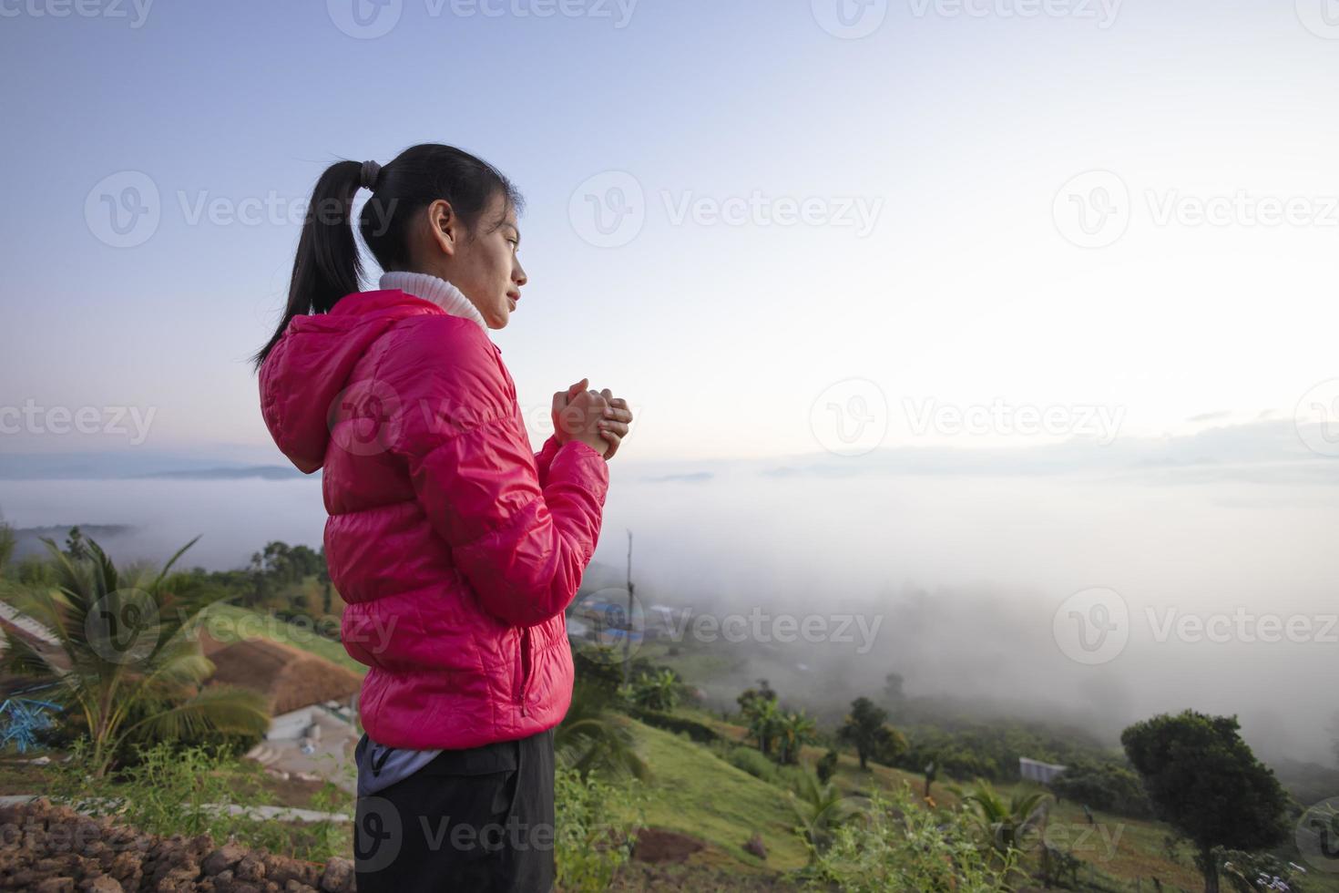 mujer rezando por la mañana sobre un fondo nublado. concepto de cristianismo. fondo de oración. fe esperanza amor concepto. foto