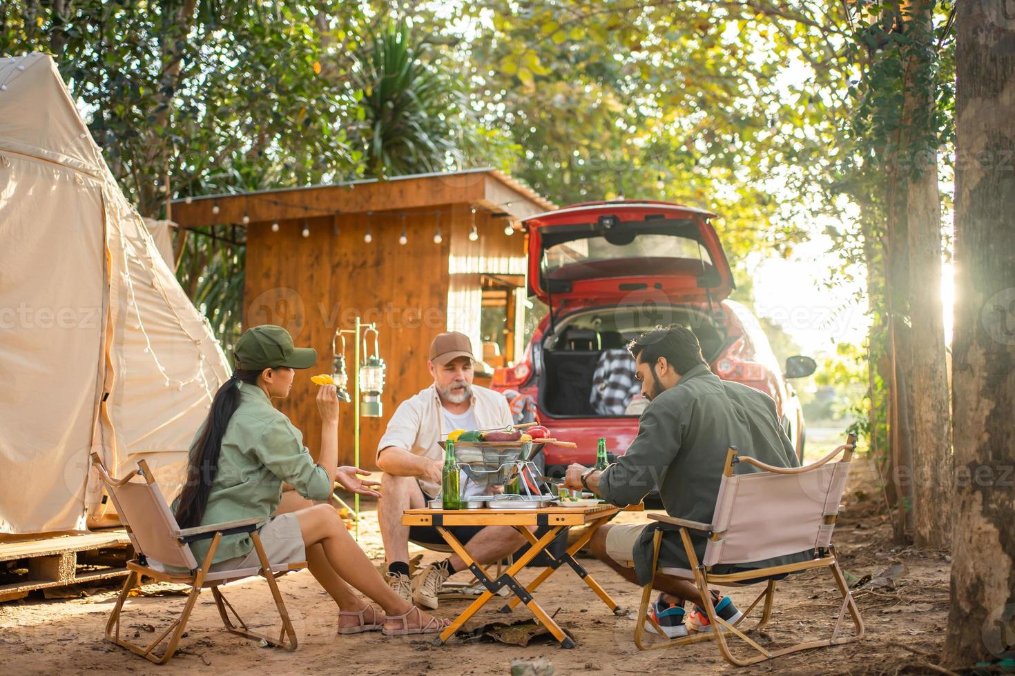 grupo de turistas amigos acampando y haciendo una barbacoa y bebiendo cerveza-alcohol con fiesta junto con disfrute y felicidad en verano foto