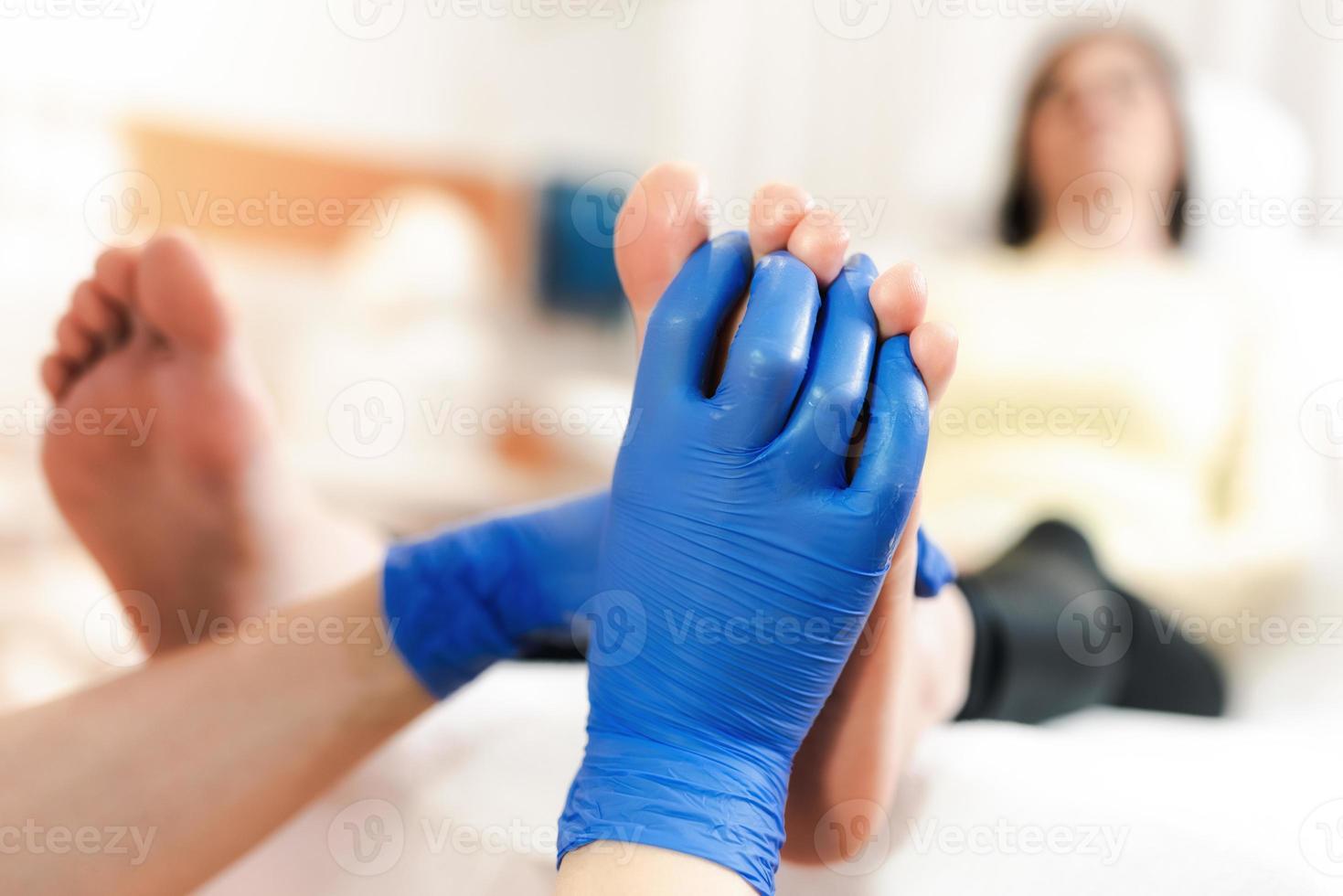 Close-up of female hands doing foot massage photo