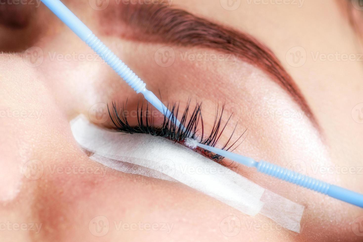 Beautician making artificial lashes. eyelash extension procedure photo