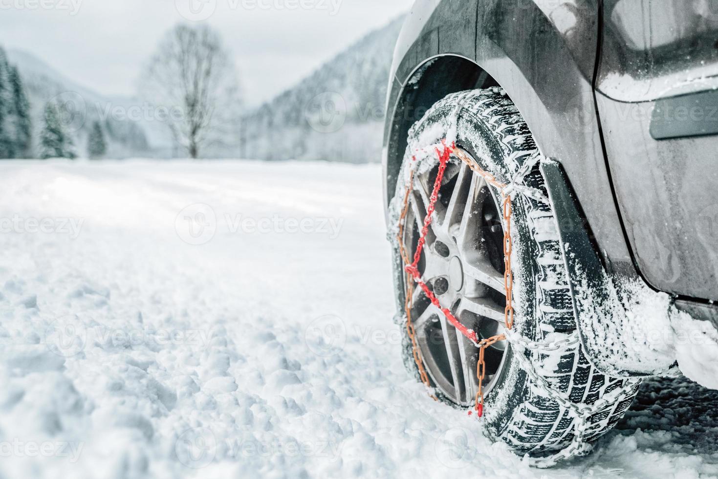 Snow chains on tire at winter snowy road photo