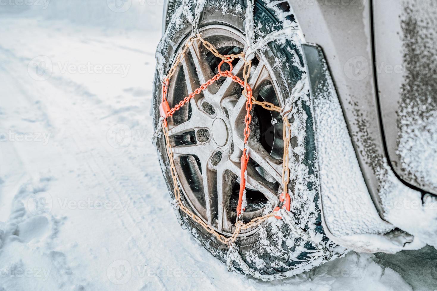 Snow chains on tire at winter road photo