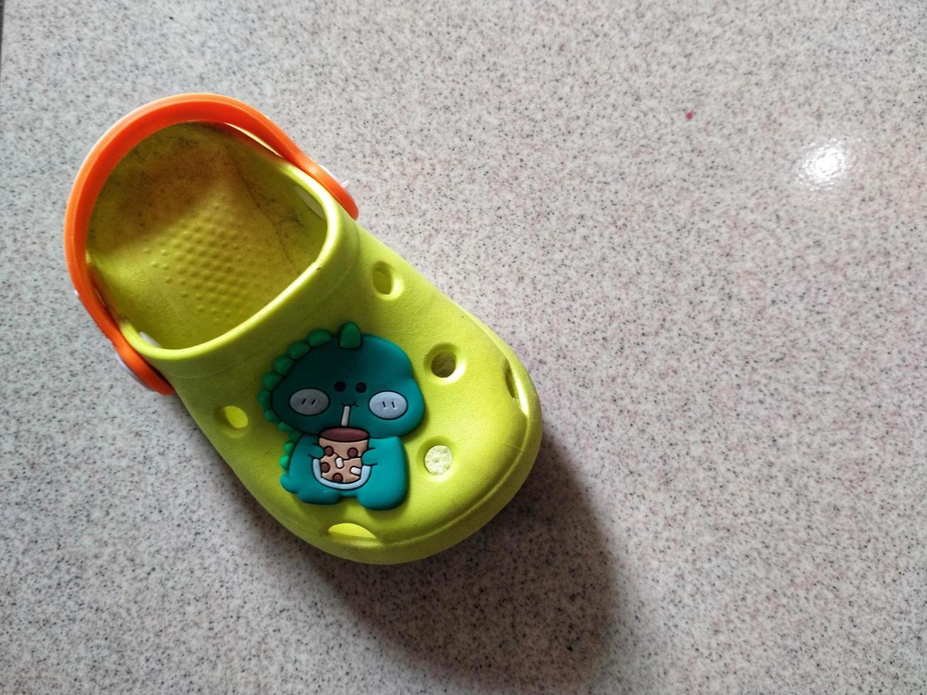 house slipper isolated on the floor background. Kids slipper with cartoon character. photo