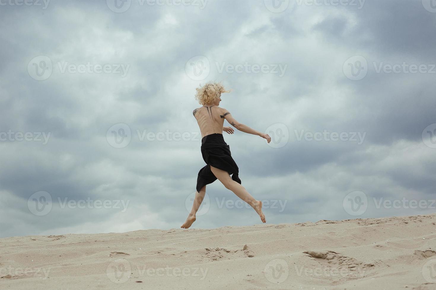 elegante mujer desnuda saltando en la fotografía escénica de la playa foto