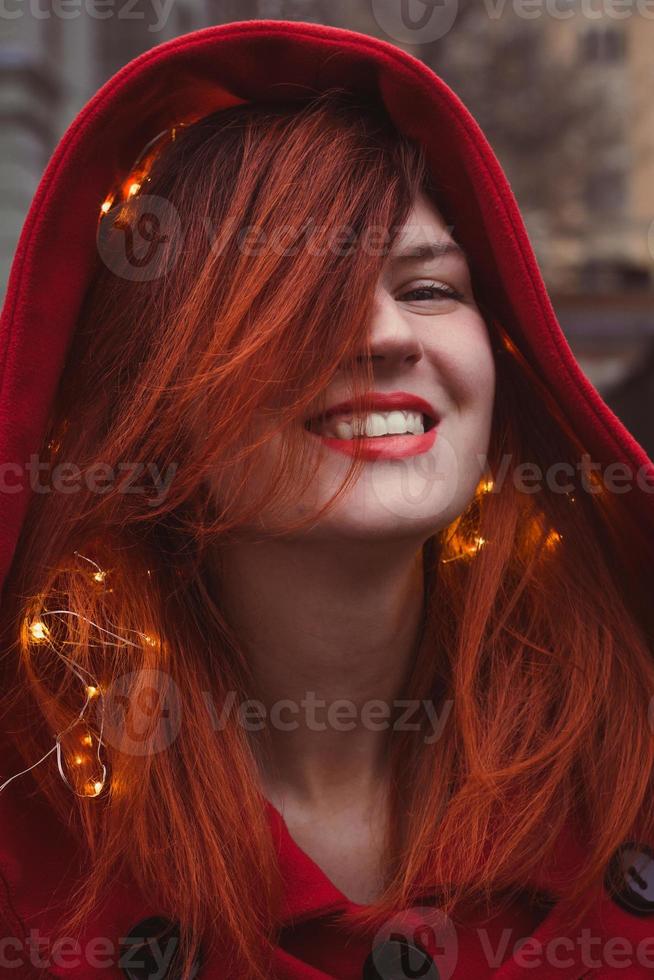 Close up joyful young woman with glowing lights in hood portrait picture photo