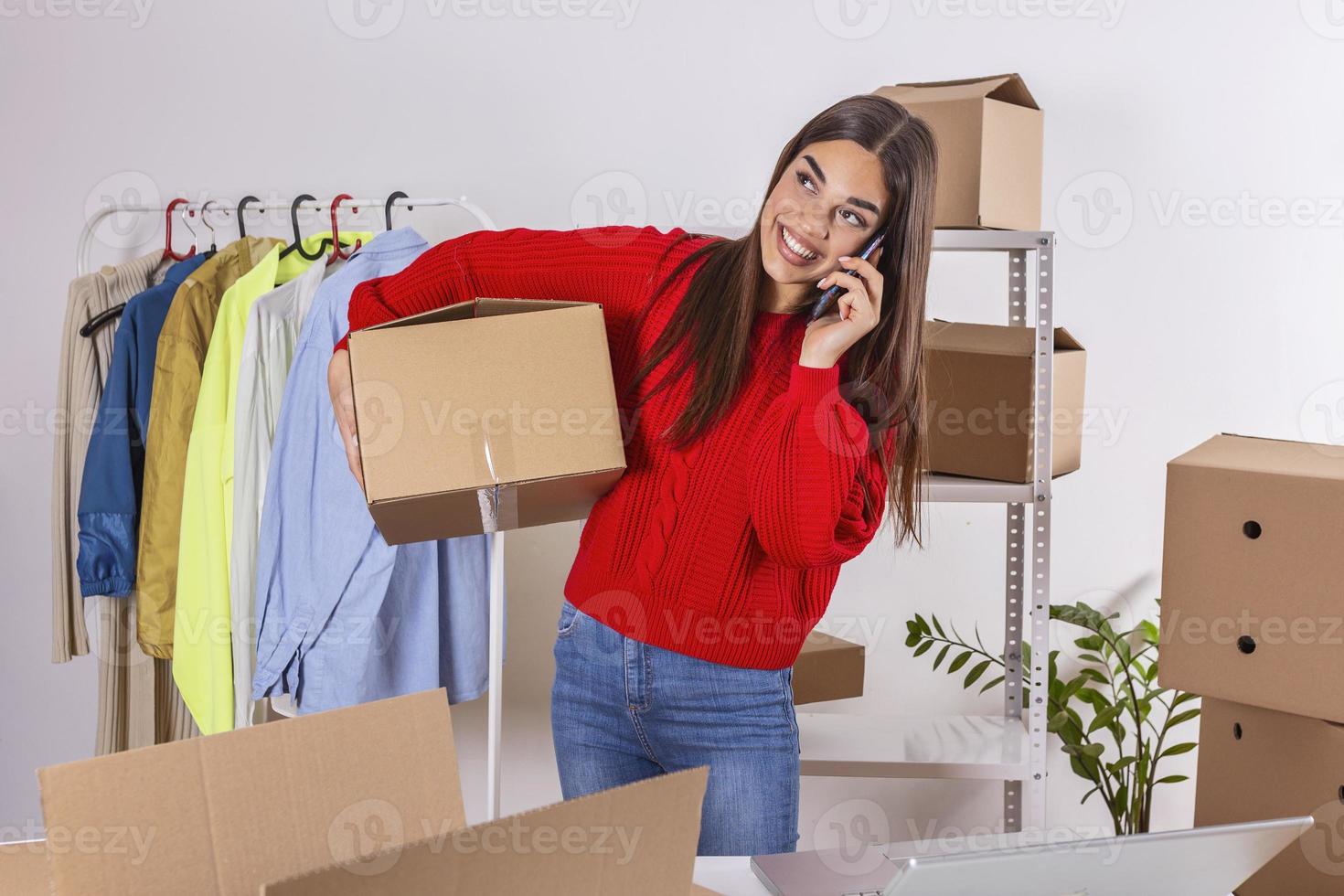 Young woman small business owner carrying product boxe at home office, online marketing packaging and delivery scene, Woman working at home concept.Beautiful girl using mobile phone photo