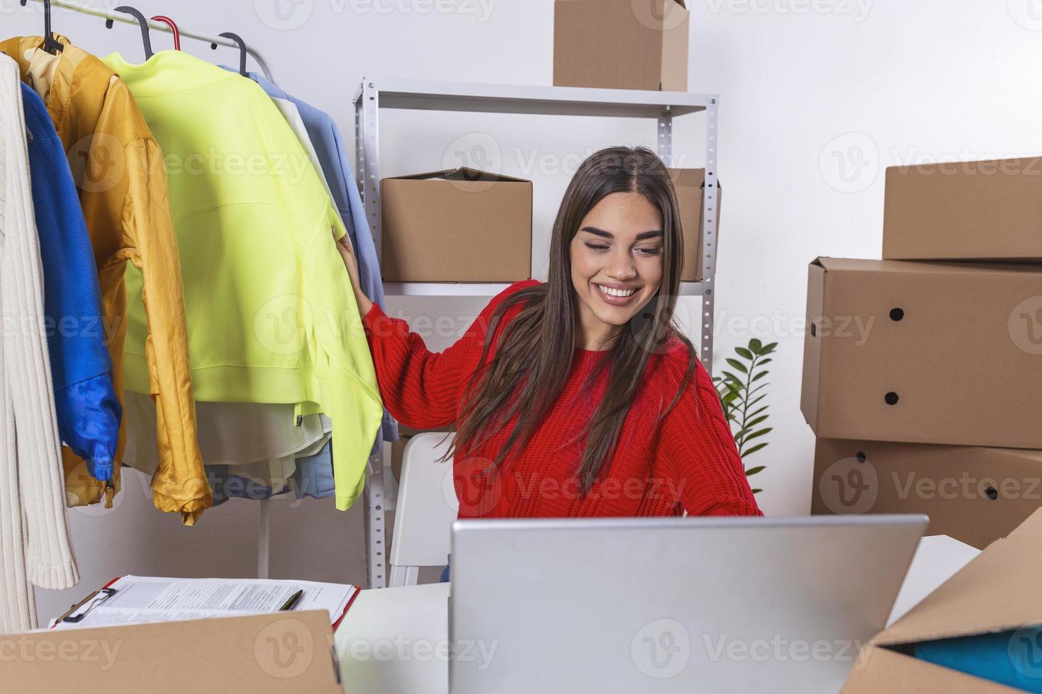 Young woman selling products online.Via video call talking with client.Online small business owner. Online using laptop receive order from customer with parcel box packaging at her startup home office photo