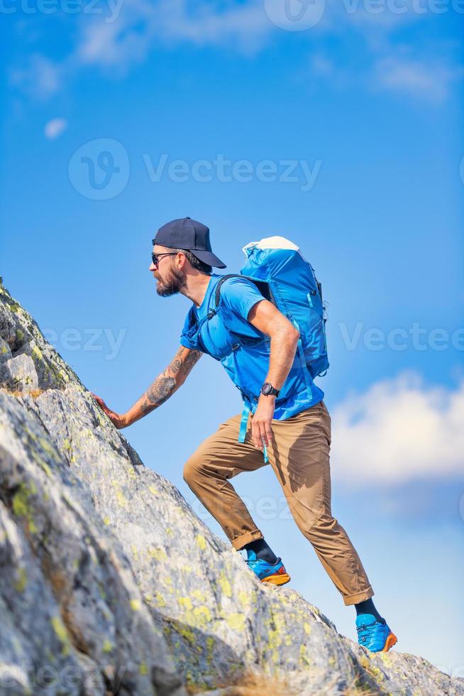A man during a mountain climb in the wild photo