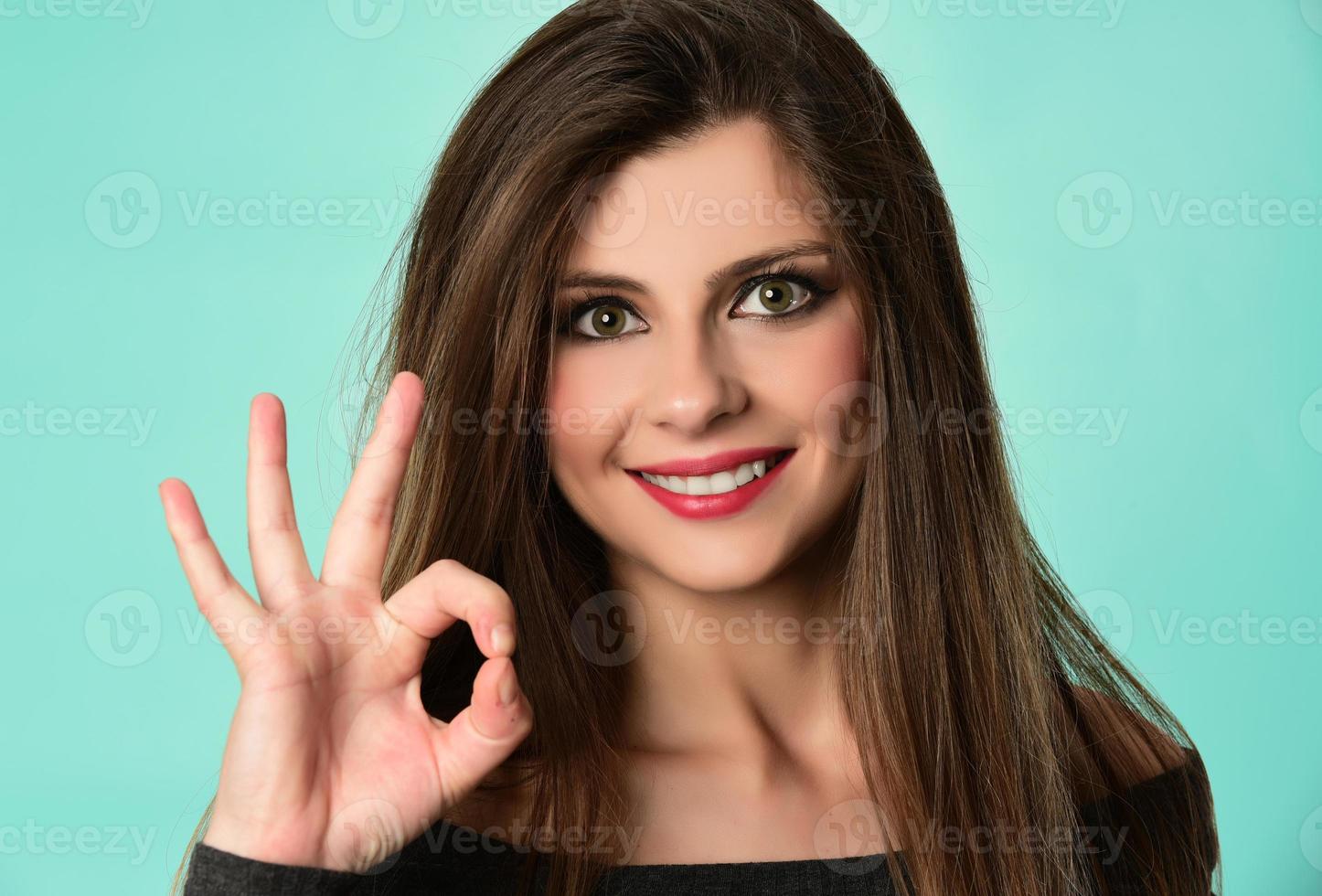 mujer que muestra los pulgares hacia arriba contra el fondo blanco foto