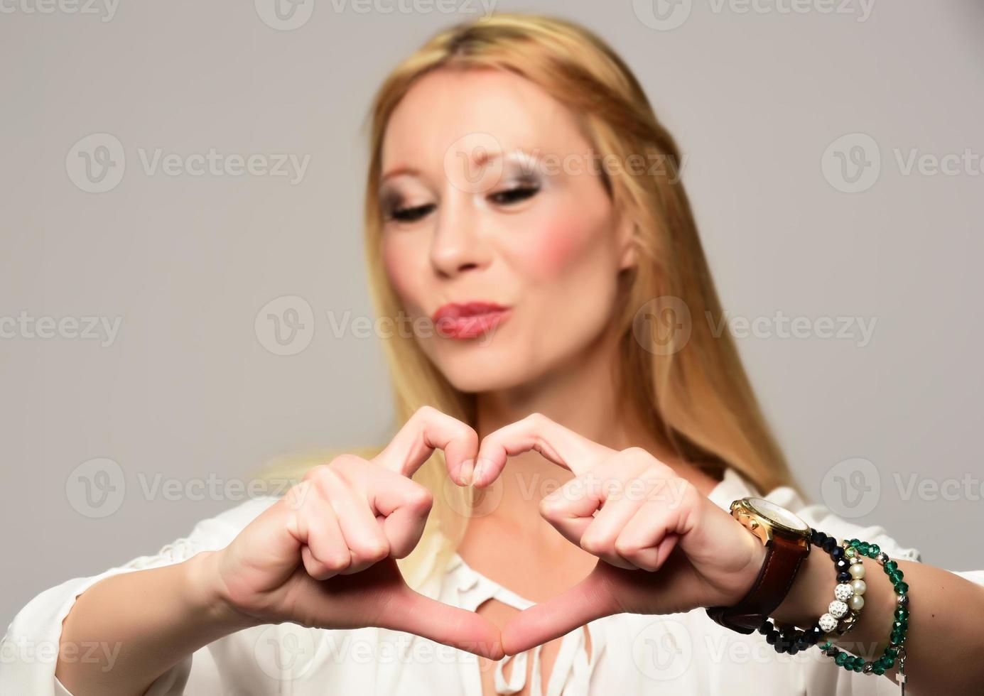 Portrait Of Beautiful Happy Woman Holding Heart Shaped Hands photo