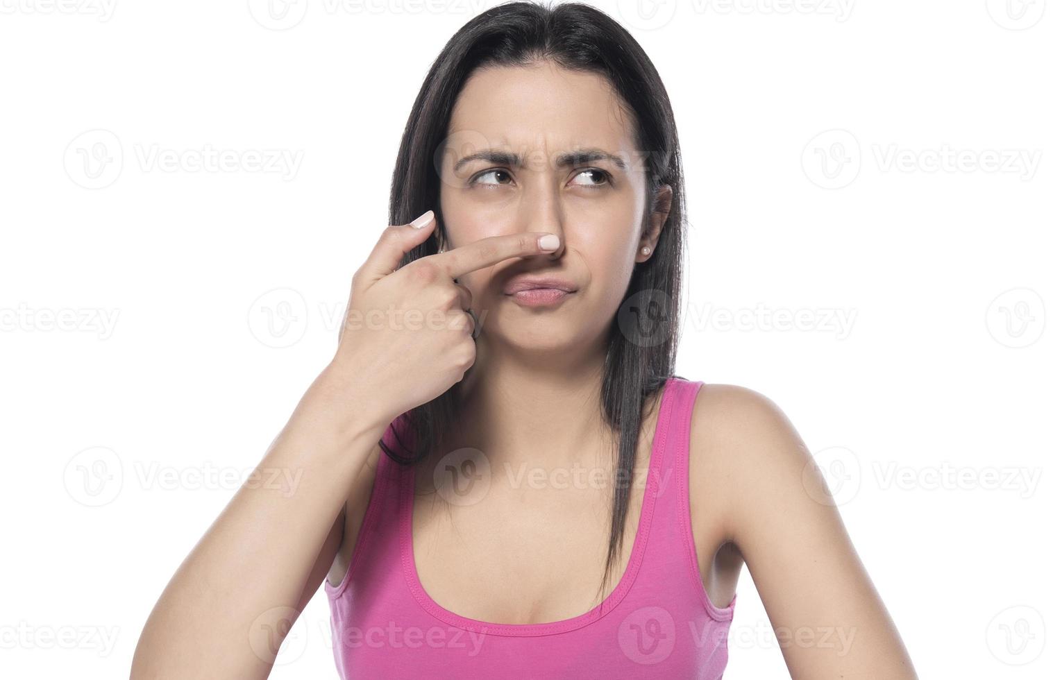 profile of young happy woman touches her nose with her finger on a white background photo