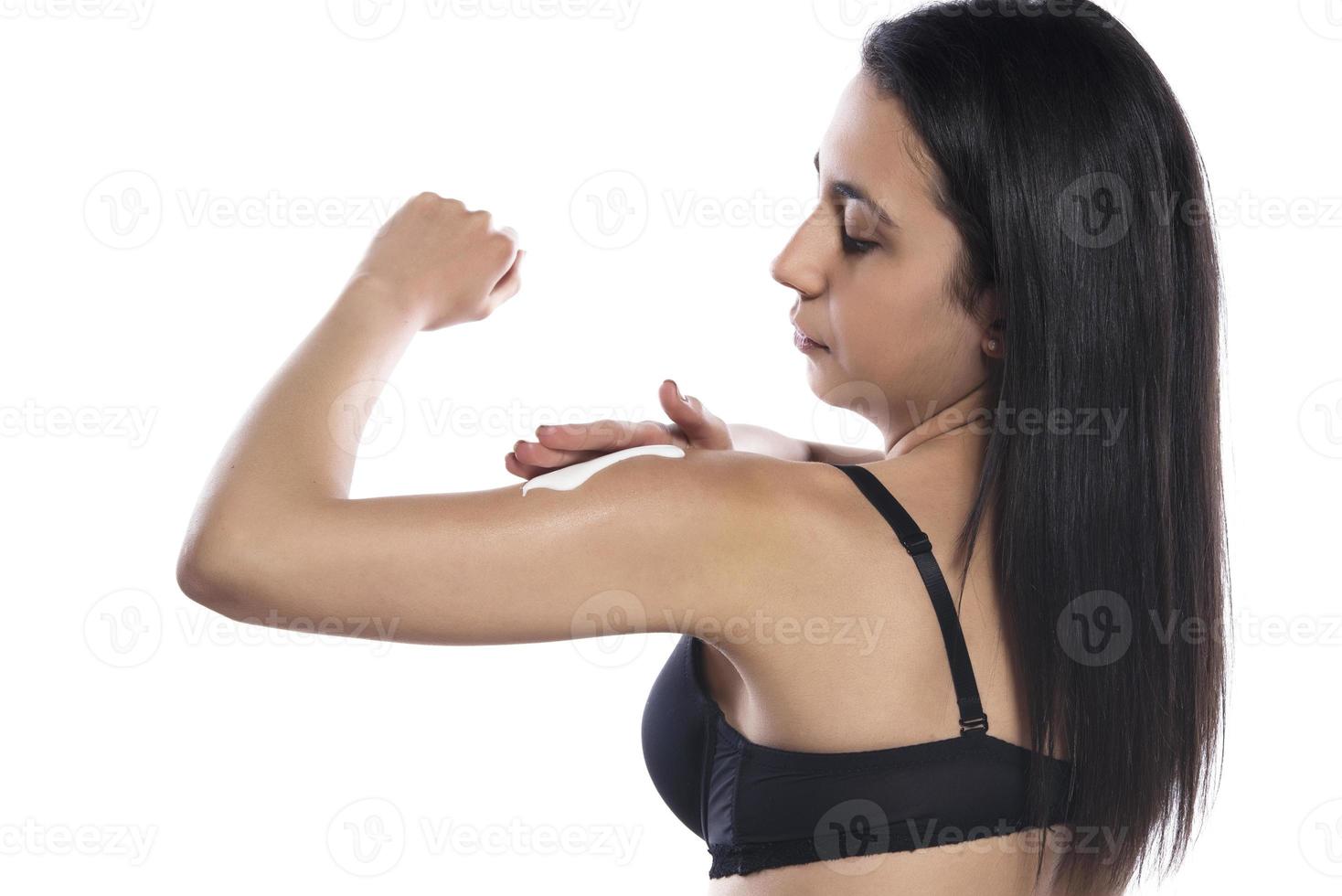 Pretty lady using moisturizer for her smooth and silky skin after morning shower photo