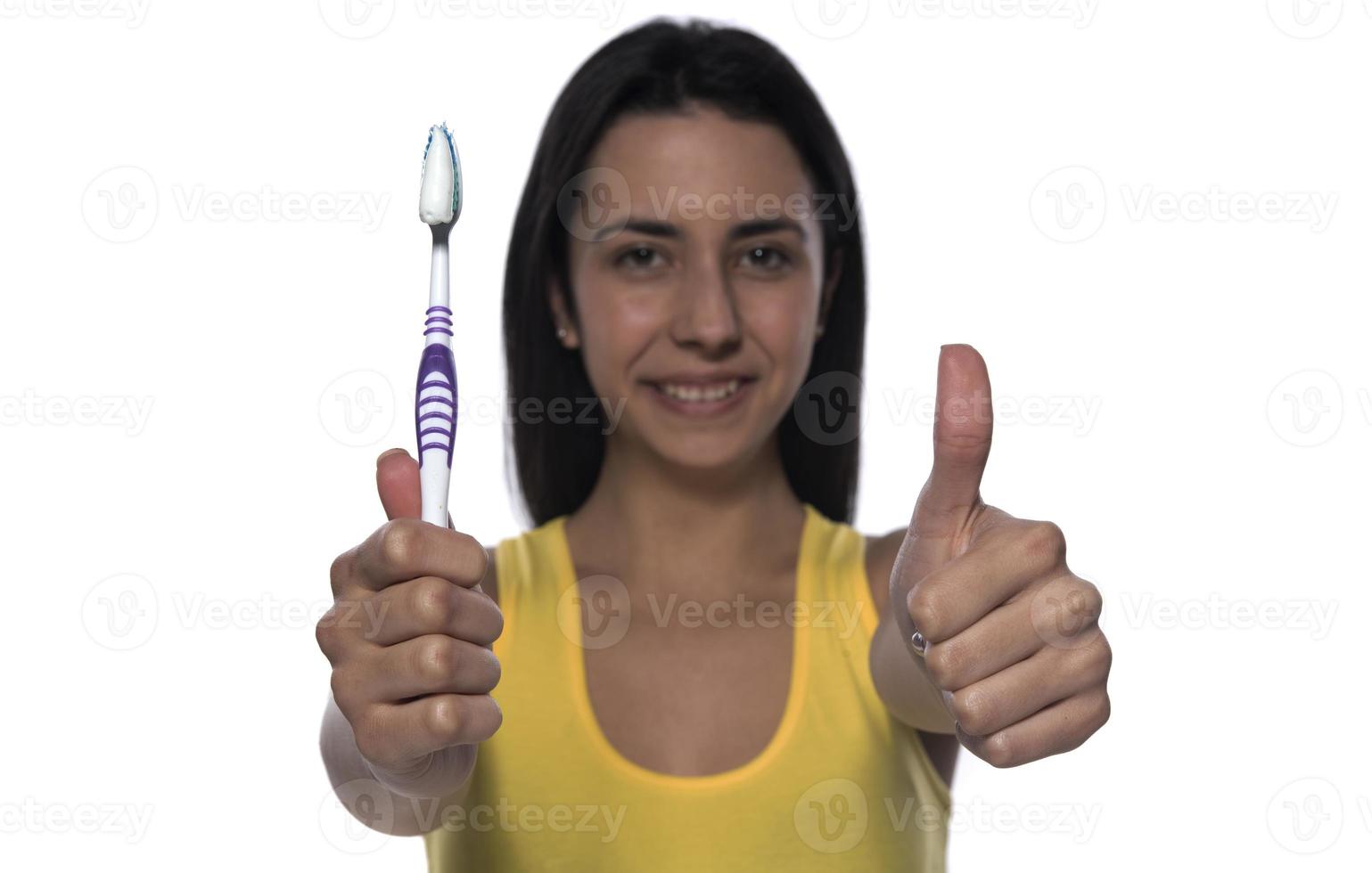 Happy young woman with healthy teeth holding a tooth brush photo