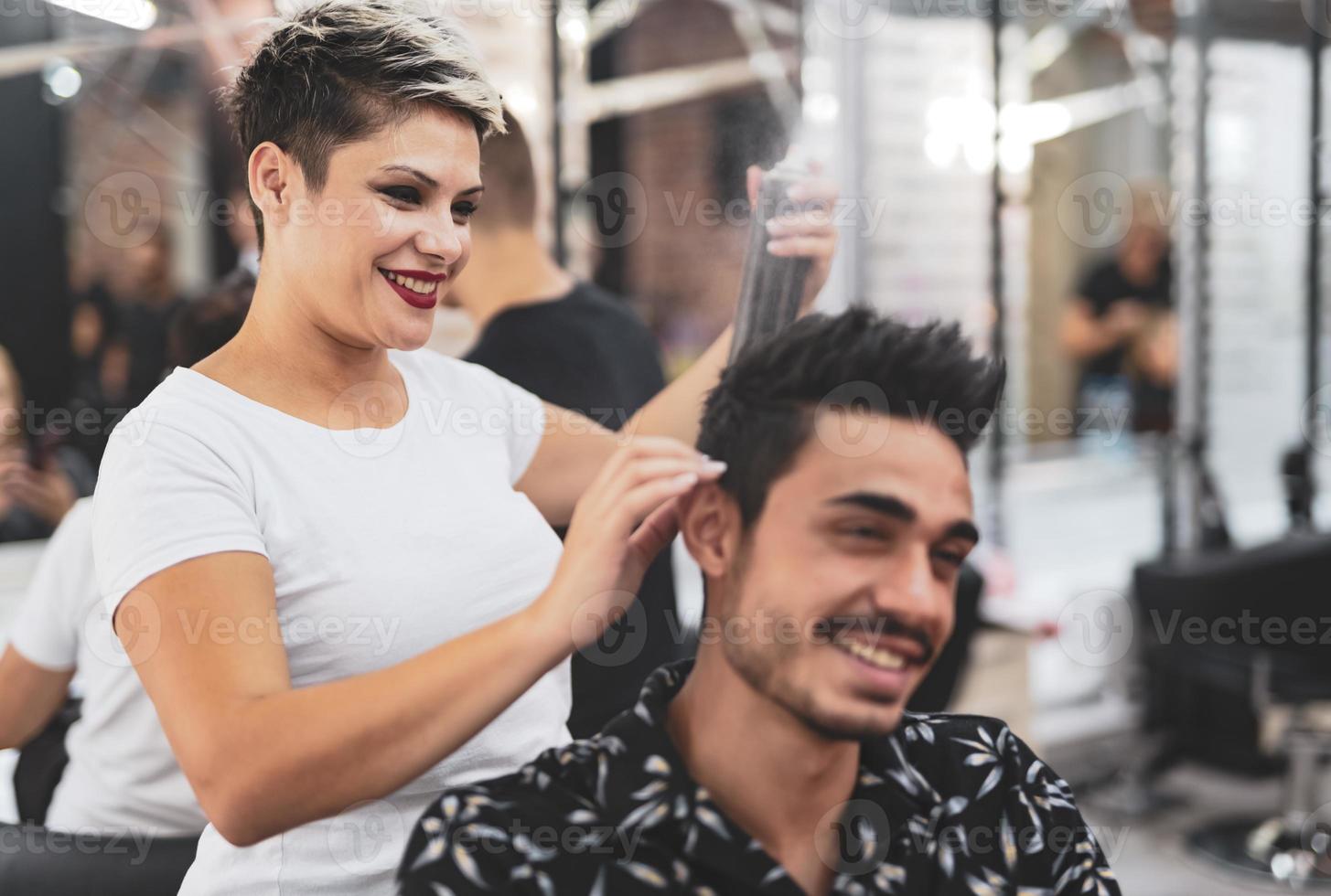 Professional hairdresser is cutting men's hair in beauty salon. photo