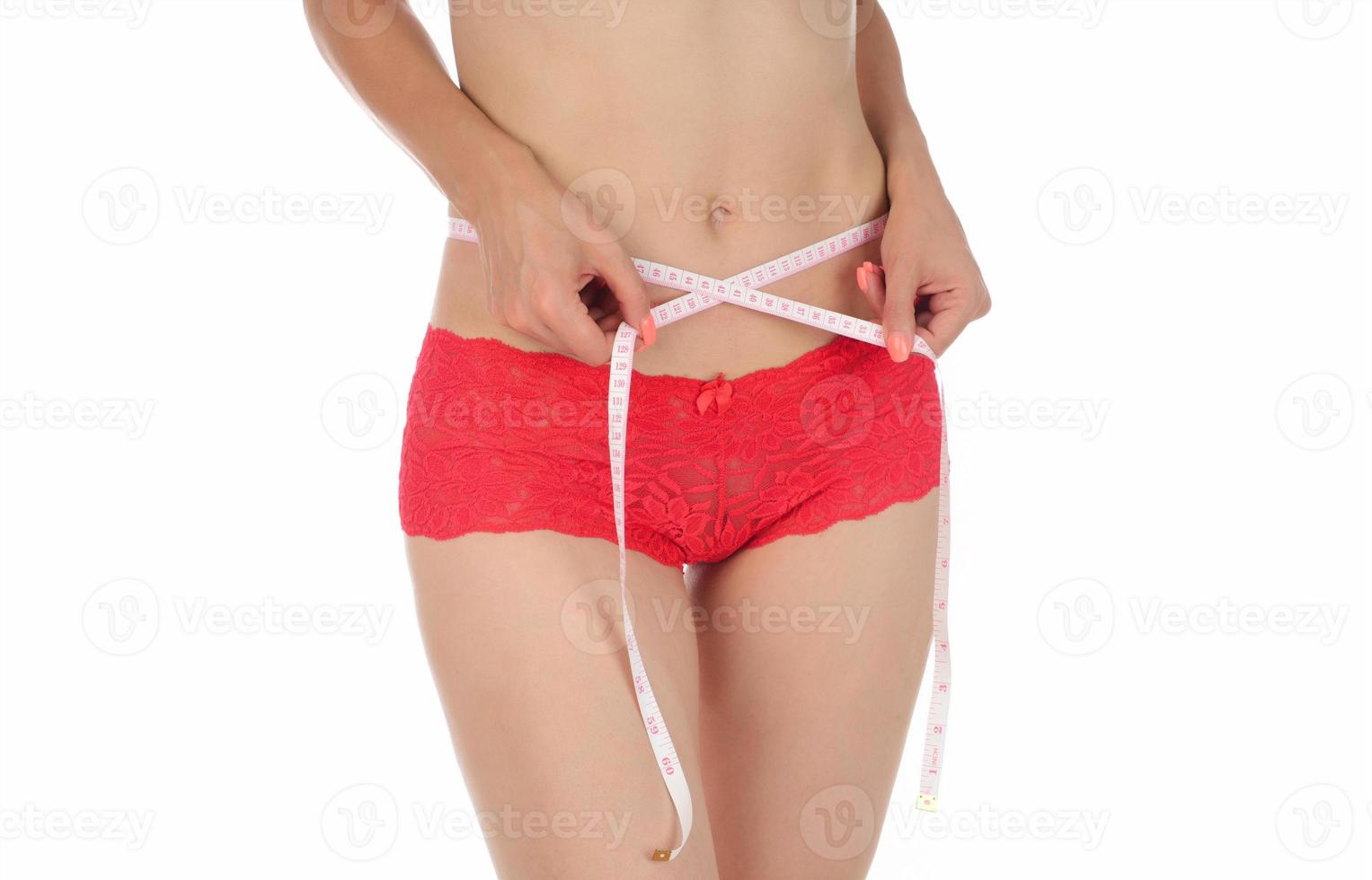 Athletic slim woman measuring her waist by measure tape after a diet photo