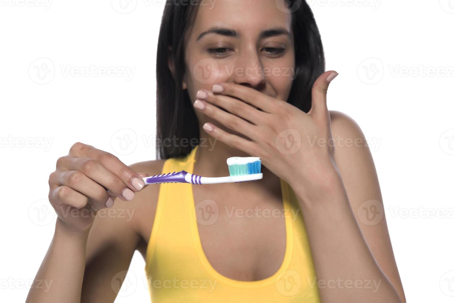 mujer joven feliz con dientes sanos sosteniendo un cepillo de dientes foto