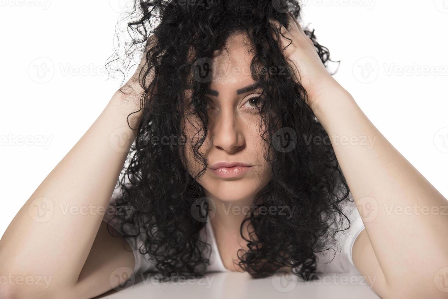 Young woman trying to comb her curly hair photo