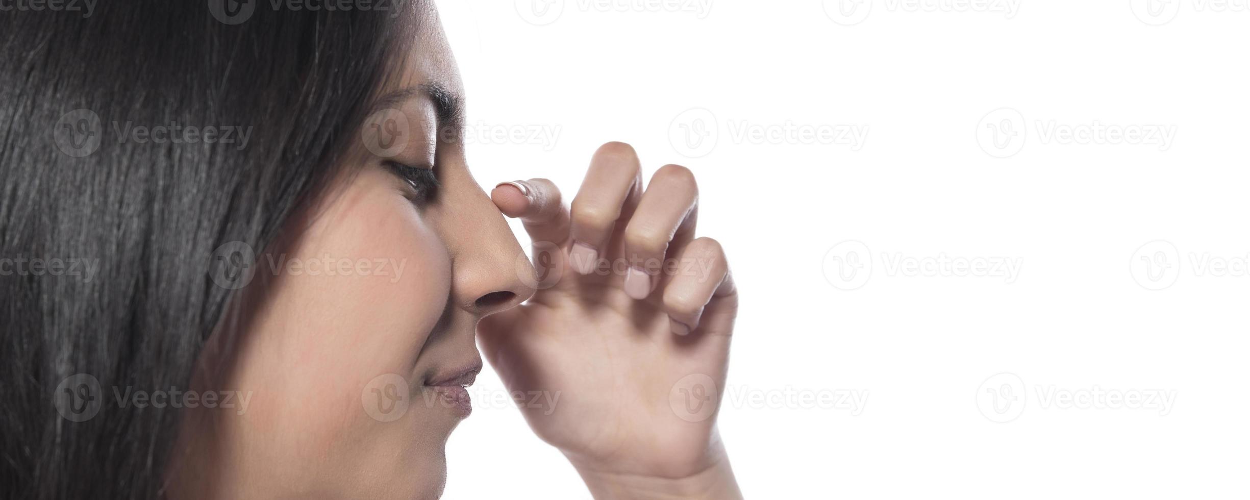 profile of young happy woman touches her nose with her finger on a white background photo