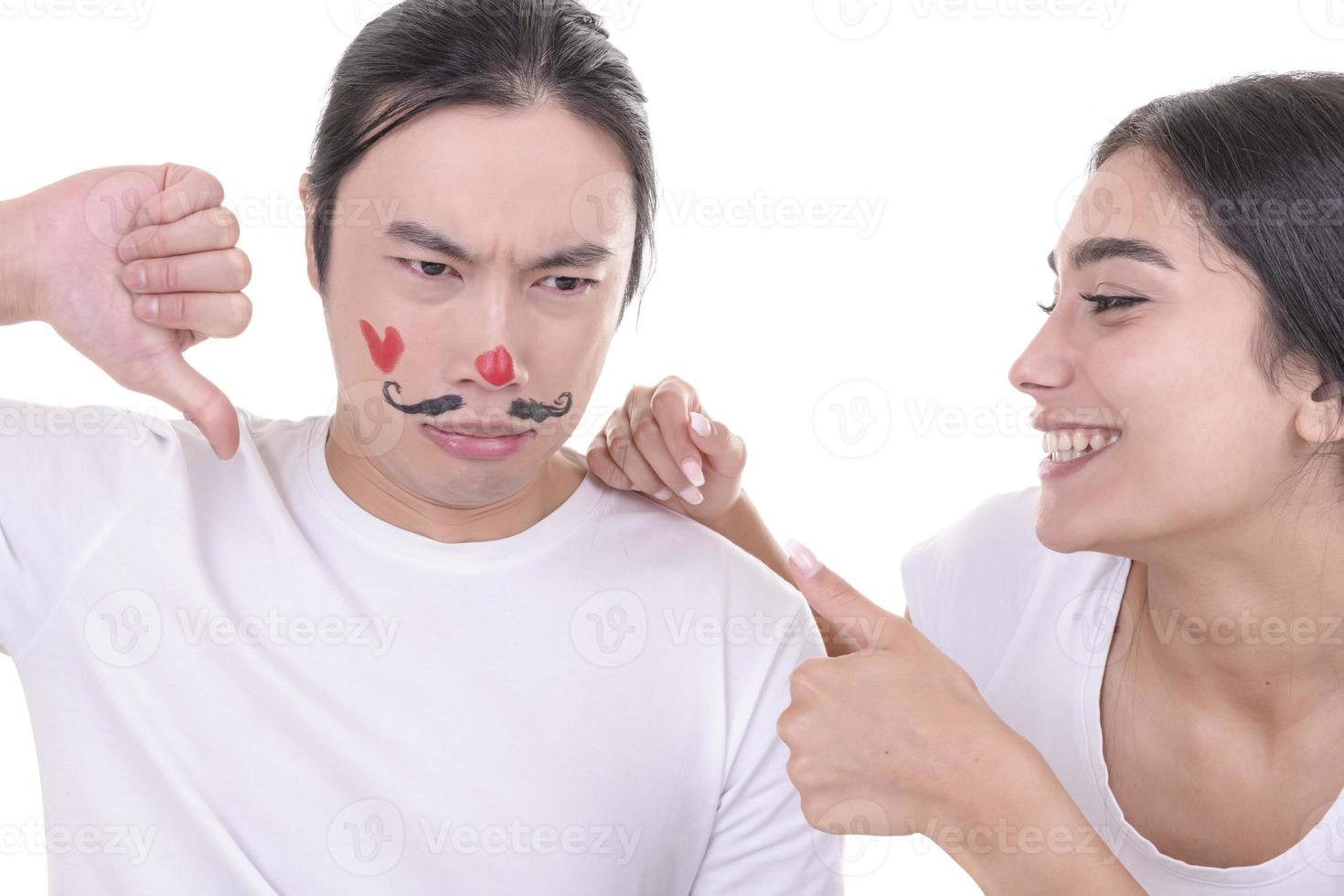 Mixed couple having fun. Arabic female model and Asian male model who have drowned mustaches and heart on his face. isolated on white background. photo