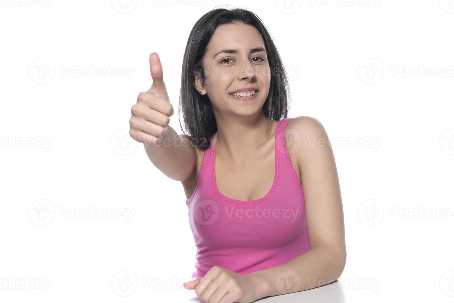 Closeup of female hand showing thumbs up sign against white background. photo