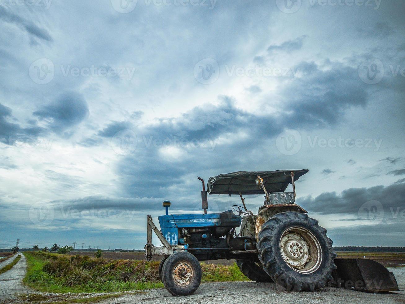 A blue tractor at the rice field photo