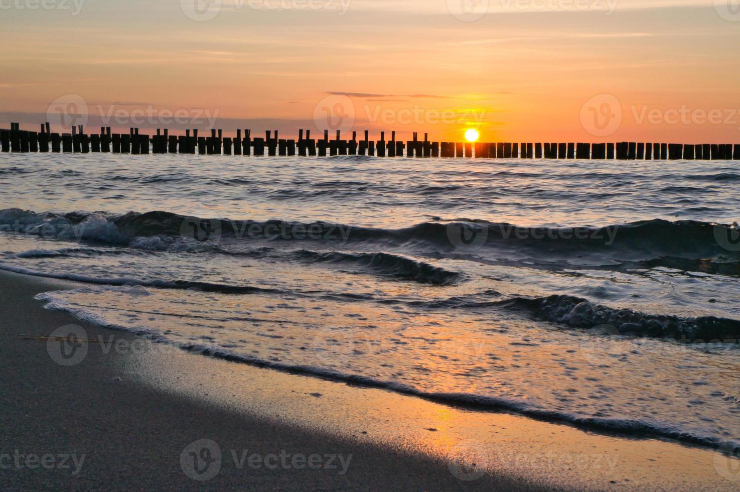 Sunset on the Baltic Sea. Sea, groyne strong colors. Vacation on the beach. Romantic photo