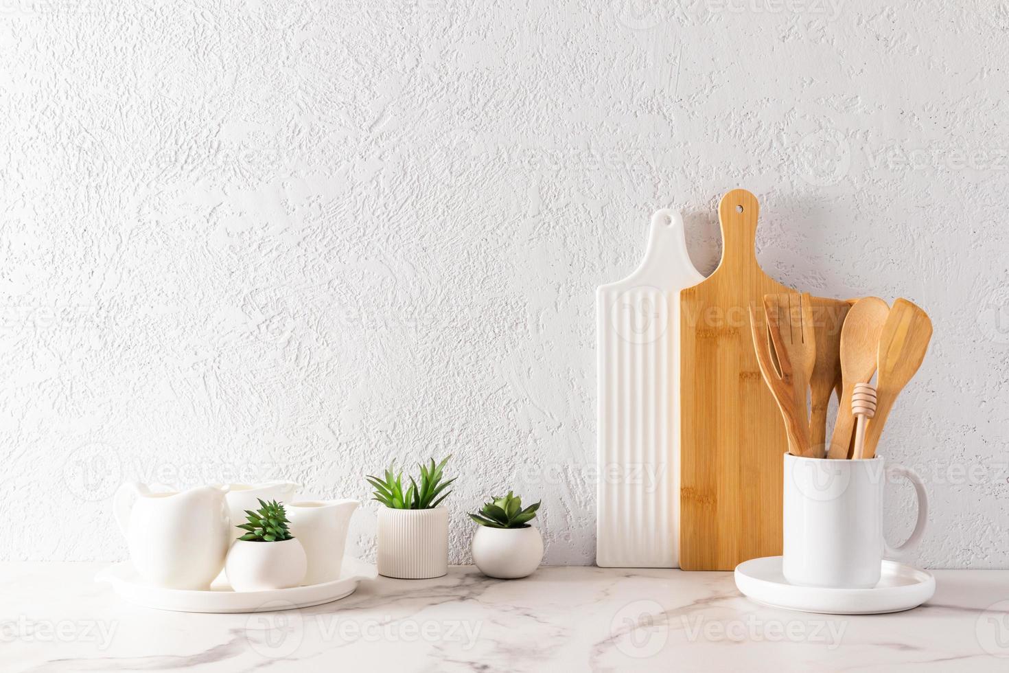 environmentally friendly items of modern tableware on a white marble countertop with green plants in mini-hills. space for text. minimalist style. photo