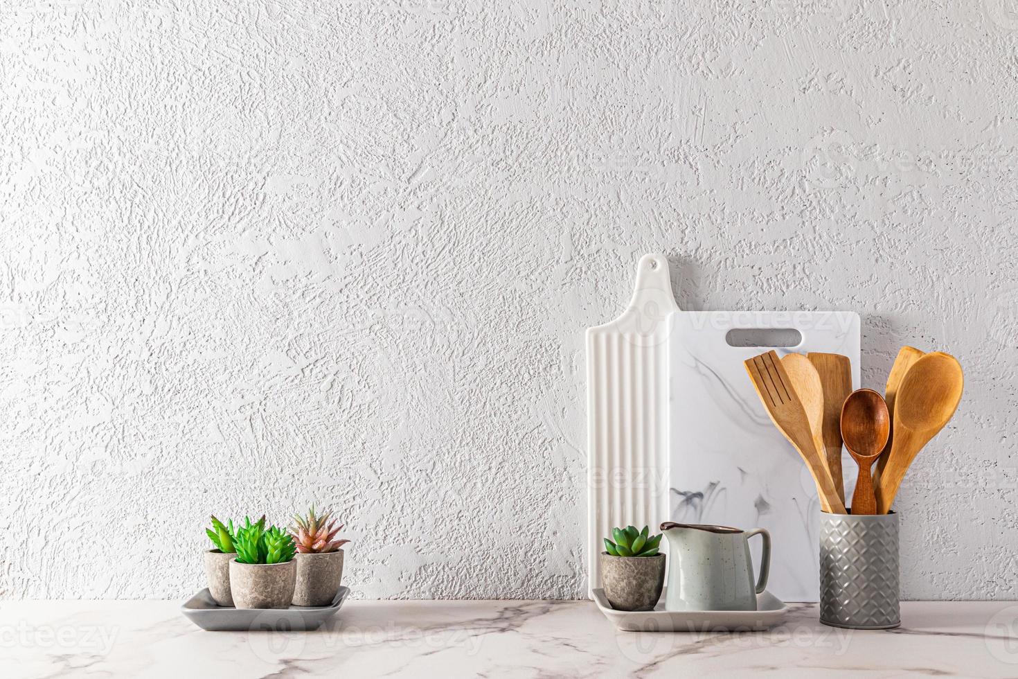 diseño moderno de la encimera de la cocina en un estilo minimalista. hermosos utensilios de cocina en una encimera contra una pared con textura gris. un espacio de copia. foto