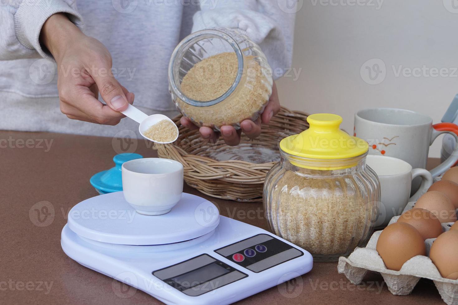 Closeup hand scales sugar for cooking, prepares eggs and other  food ingredients for make cookies. Concept, cooking , bakery. Love cooking lifestyle. Pastime activity. Kitchen photo