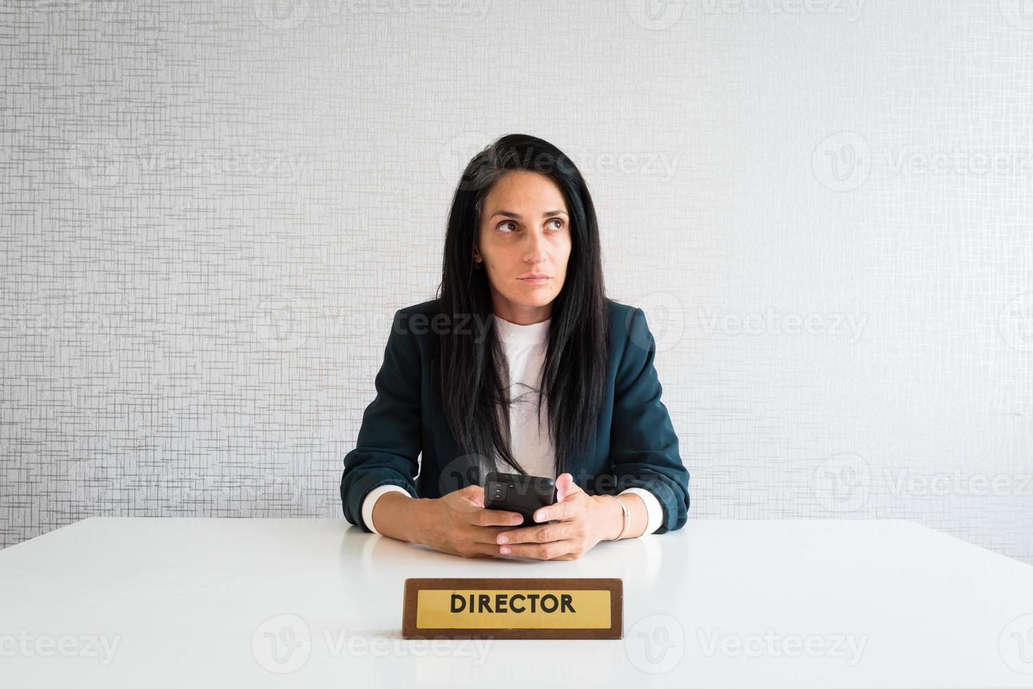 Young caucasian brunette business woman director in office thoughtful entrepreneur hold phone make decisions think before text r mock up isolated photo