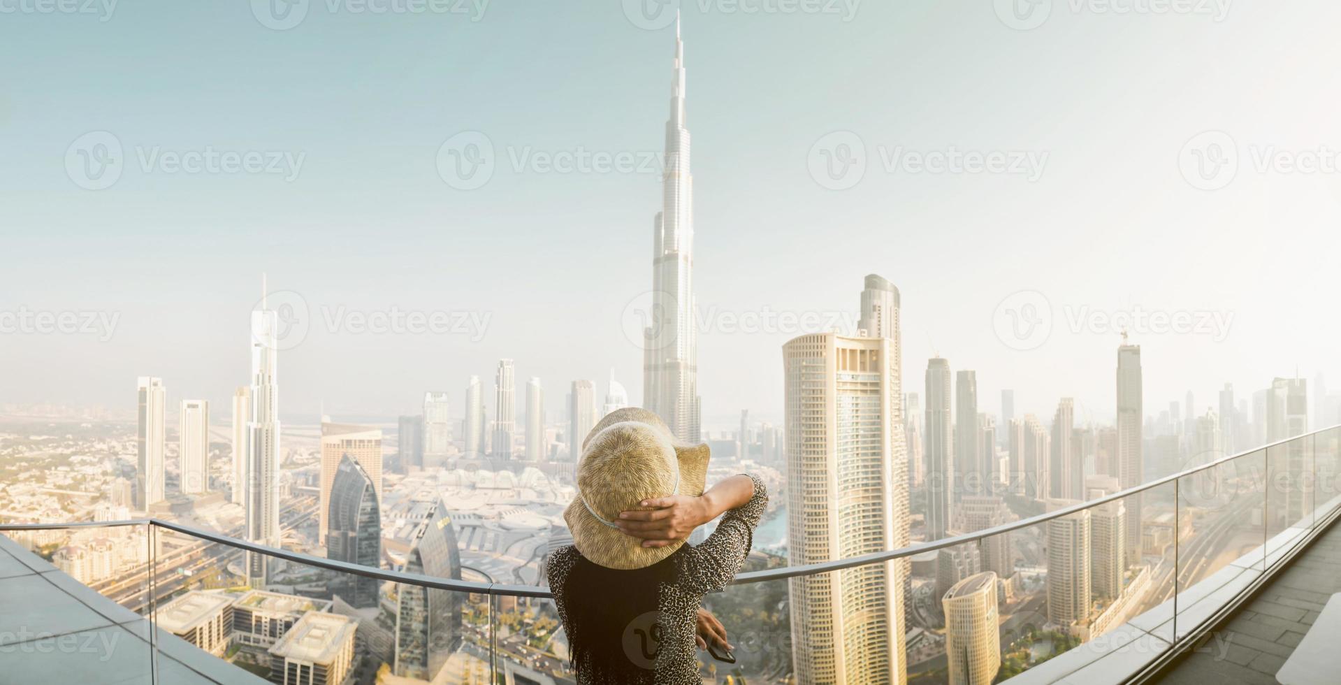 Dubai, UAE, 2022 - Burj Khalifa View from sky view downtown, lady by infinity pool looking at the tallest building in the world. Visit Dubai sky view hotel on holiday photo
