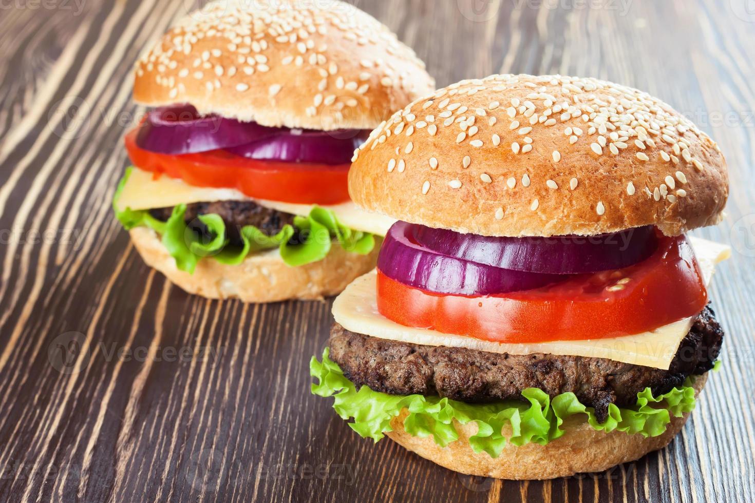 Homemade cheeseburger on brown wooden surface. photo