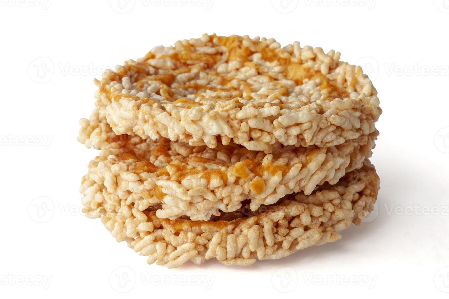 Stack of Thai sweet crispy rice cakes with cane sugar drizzle Thai people call Khaotan isolated on white background. photo