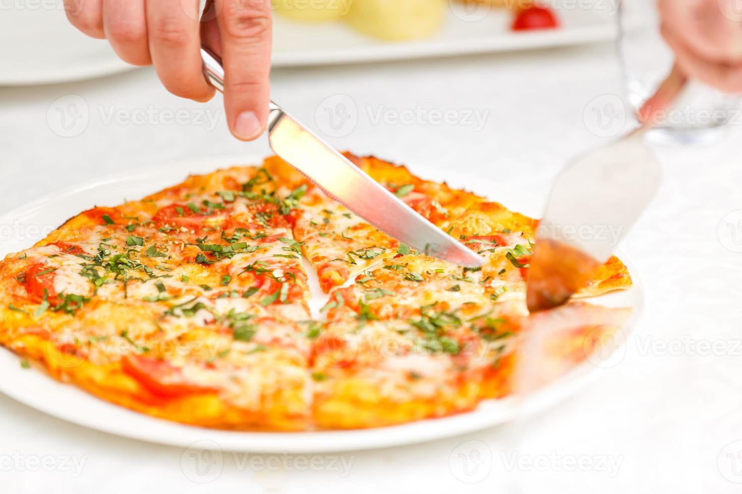 the waiter cuts pizza photo