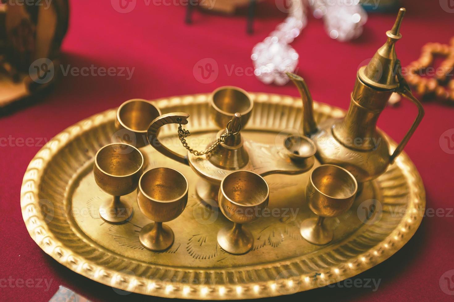 Golden tea set with tray tea pot and glasses in the antique shop vintage style photo
