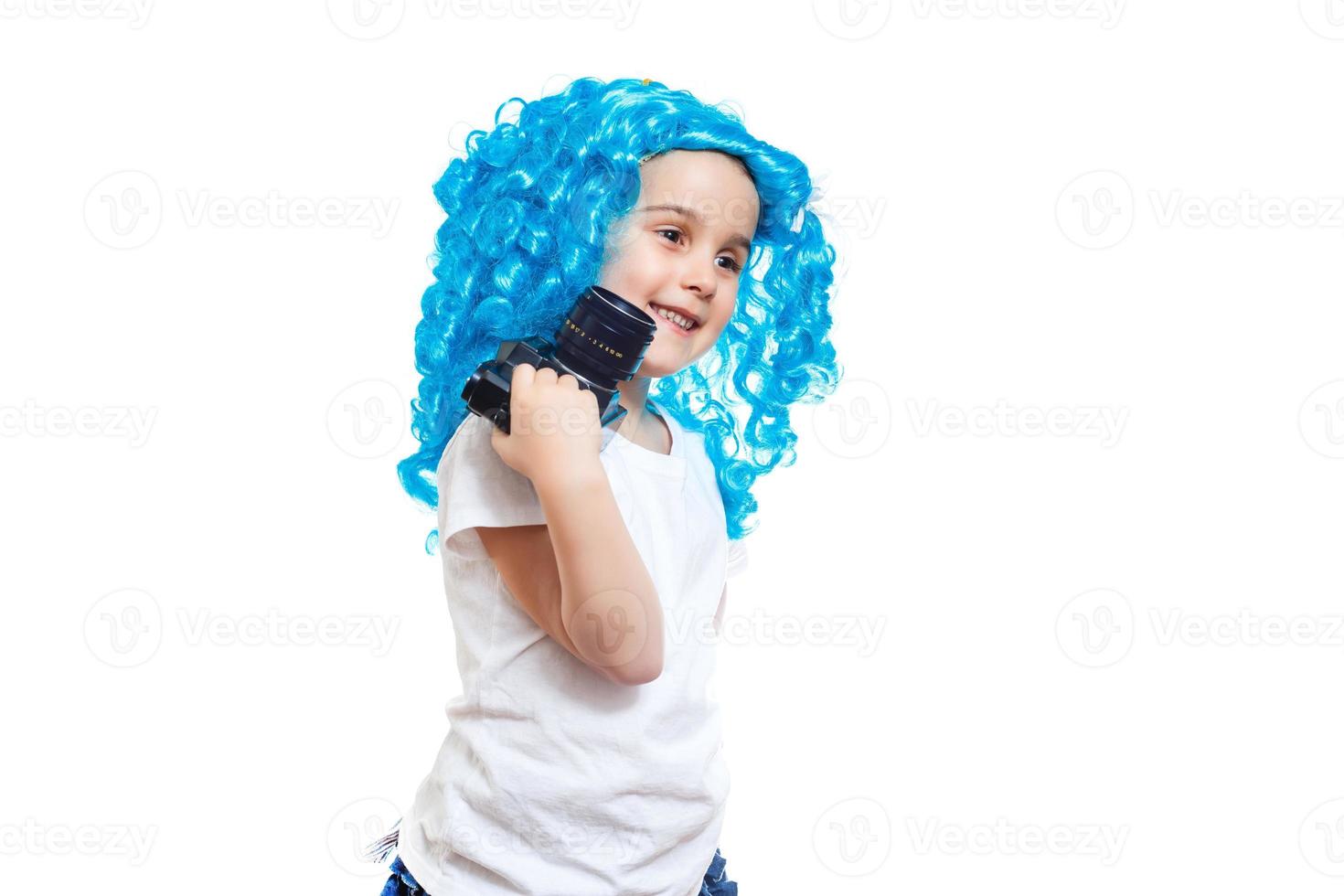 Pretty little girl posing in the blue wig with a professional retro camera photo