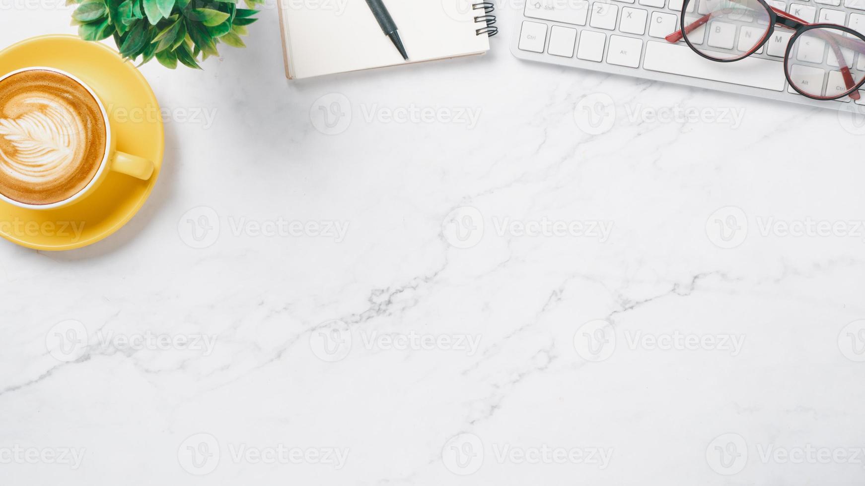 White office desk workspace with keyboard computer, eyeglass, notebook, pen and cup of coffee, Top view flat lay with copy space. photo