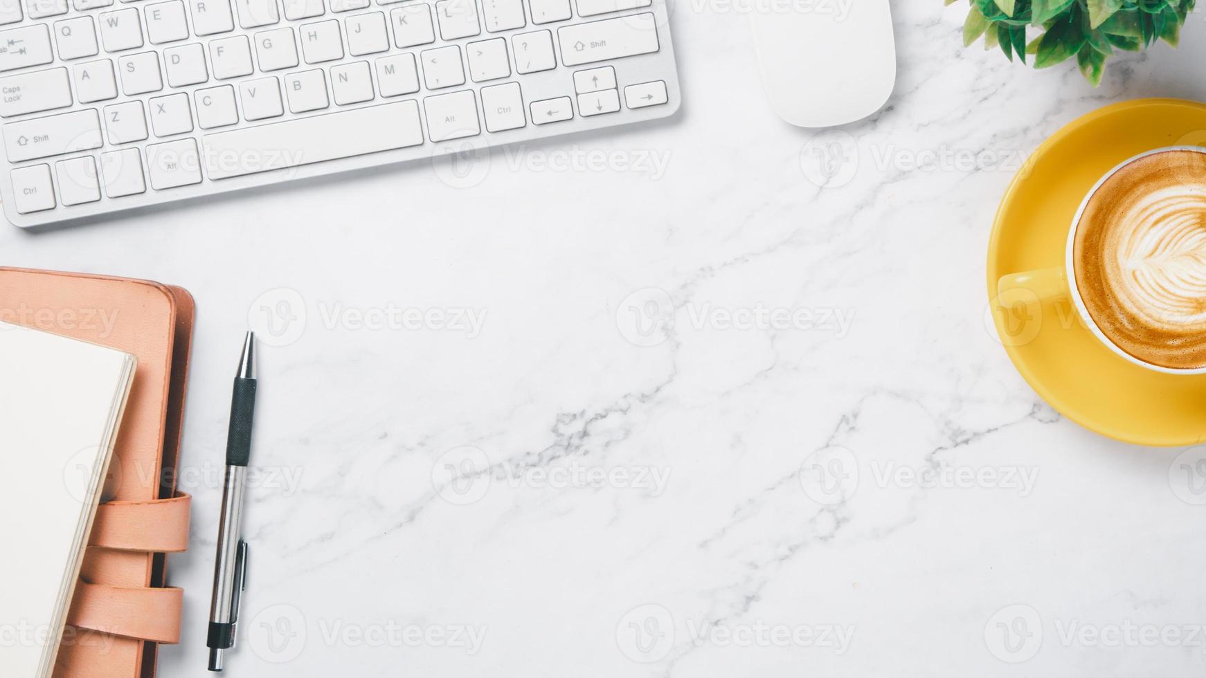 White office desk workspace with keyboard computer, mouse, notebook, pen and cup of coffee, Top view flat lay with copy space. photo