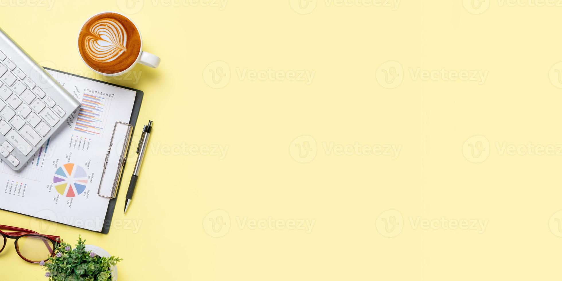 Office desk table with analysis chart or graph, pen, cup of coffee and calculator on yellow background. Top view with copy space.Working desk table concept. photo