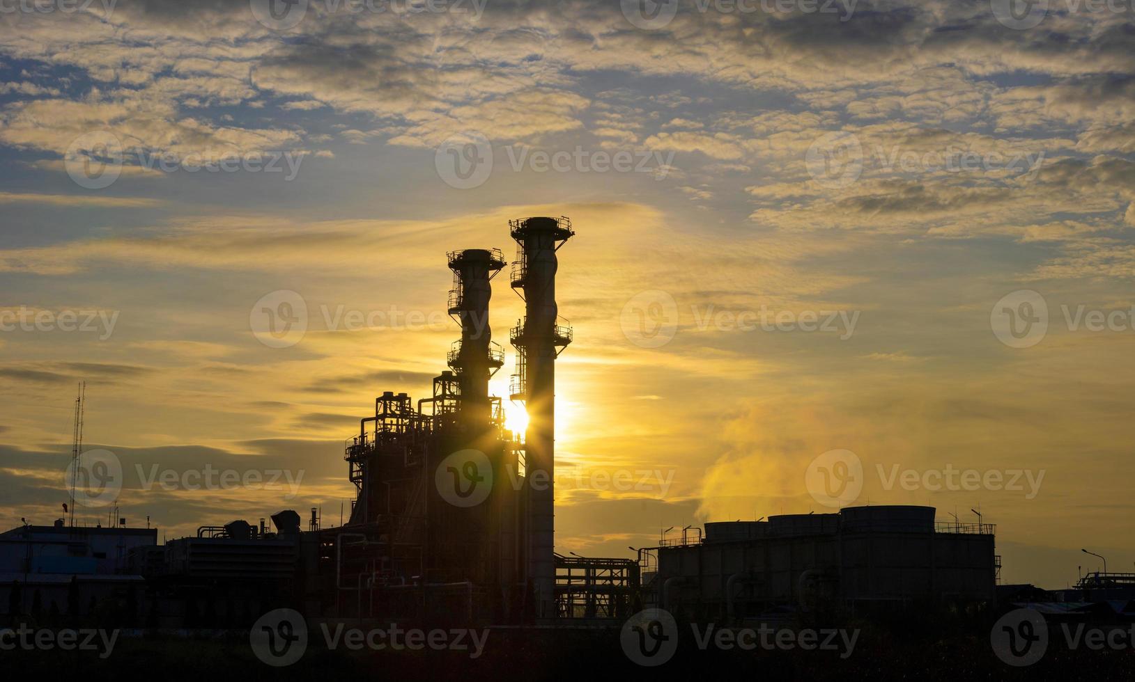 Silhouette of gas turbine power plant at sunset which create pollution and global warming cause ozone layer depletion for electricity and energy concept photo